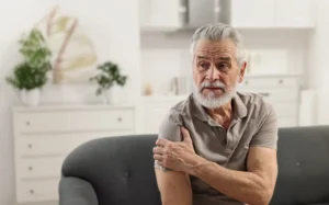 Man holding his shoulder in discomfort from arthritis